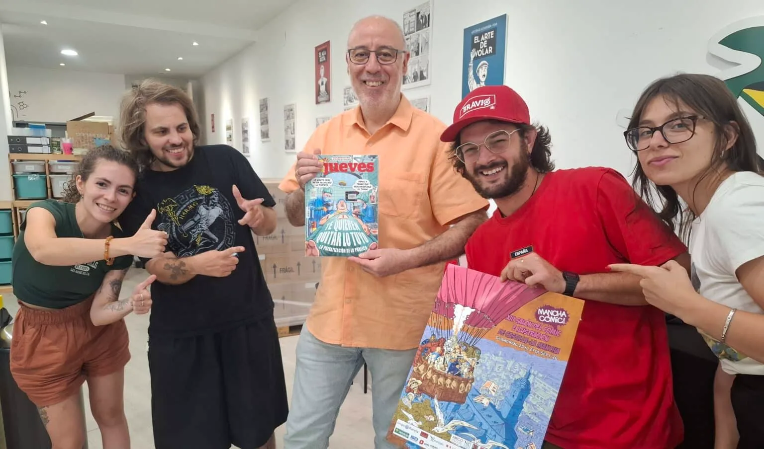 Parte del equipo de Manchacomic con una publicación de jueves y el cartel del evento Foto Cortesia Lanza Digital.