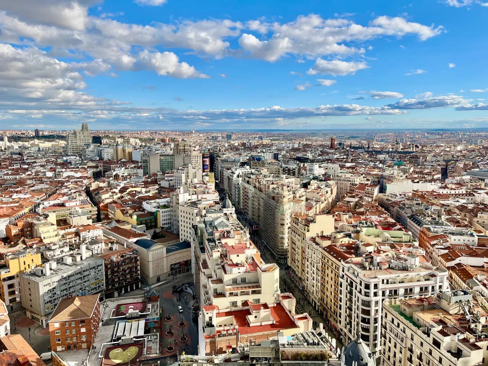 Impresionante vista aérea del horizonte de Madrid con un paisaje urbano vibrante bajo un cielo azul.